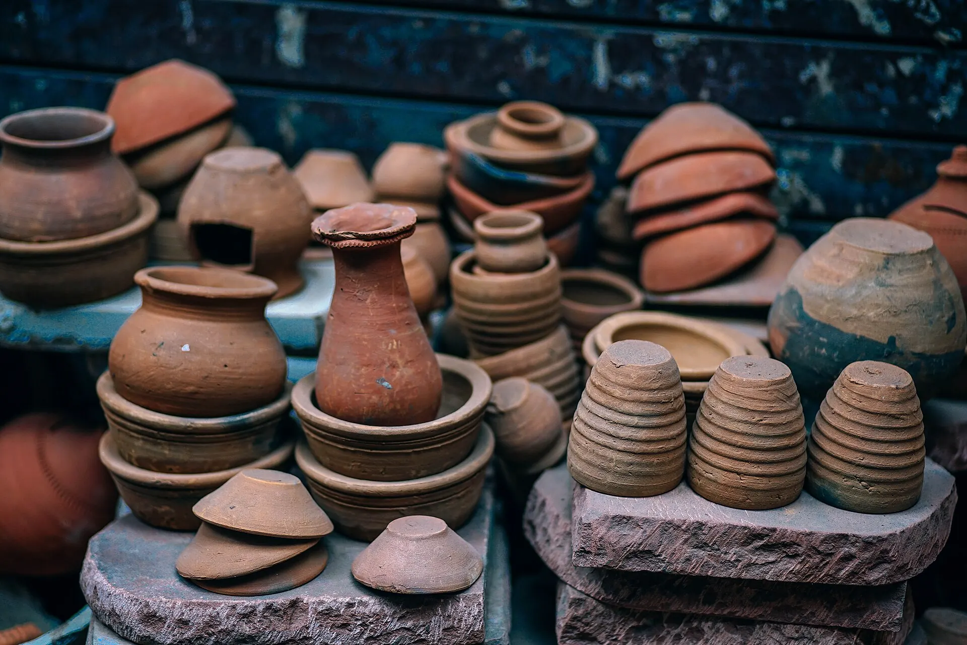 Étals de pots, coupelles et vases en terre cuite empilés.